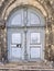 Vertical shot of a vintage arched door with steps infront