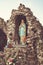 Vertical shot of the Virgin Mary statue inside stone carved wall