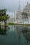 Vertical shot of Wat Rong Khun temple and its reflection on the lake at Chiang Rai, Thailand