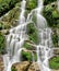 Vertical shot of a waterfall cascading over mossy rocks