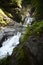 Vertical shot of a waterfall cascading over stones