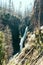 Vertical shot of a waterfall falling from the middle of enormous rocks