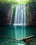 Vertical shot of a waterfall reflecting on the water