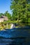 Vertical shot of a waterfall, trees and a house