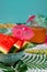 Vertical shot of watermelon wedges, carrot juice,tiny umbrellas on colorful tablecloth