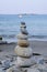 Vertical shot of well-balanced stacked pebbles at the beach with a blurry background