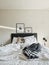 Vertical shot of a well-lighted white bedroom with a matted bed and interior stuff