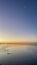 Vertical shot of a wet sandy beach of Morecambe Bay at sunset in Cumbria, England