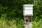 Vertical shot of  white beehive and green trees in the garden