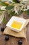 Vertical shot of a white bowl full of olive oil on a wooden surface