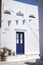 Vertical shot of a white building with a blue door in Chora, Amorgos Island in Greece