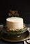 Vertical shot of a white happy birthday dream cake with green leaves at the bottom