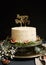 Vertical shot of a white happy birthday dream cake with green leaves at the bottom