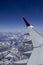 Vertical shot of the wing of an airplane over the snowy mountains