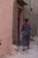 Vertical shot of a woman dressed in Arabic clothes walking on a street in Medina