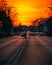 Vertical shot of a woman passing a street in Bucharest against a golden sunset sky