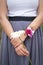 Vertical shot of a woman wearing a wristlet corsage while holding a white flower