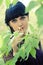 Vertical shot of a women in green leaves, summertime fashion