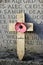 Vertical shot of a wooden cross leaned on a headstone