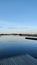 Vertical shot of a wooden dock jutting into a tranquil body of water