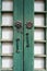 Vertical shot of a wooden green rural door with metallic rustic handles