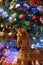 Vertical shot of a wooden handmade horse on the blurred Christmas tree background