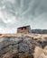 Vertical shot of a wooden house on the top of the rock - host village in Greenland, Assaqutaq