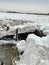 Vertical shot of wooden pier on frozen Morecambe Bay, Cumbria, England on a cloudy day