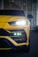 Vertical shot of the yellow Lamborghini Urus Front with headlights on