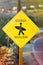 Vertical shot of a yellow road sign surfer crossing on the road to the beach