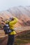 Vertical shot of a young boy photographing the mountains in Landmannalaugar, Iceland