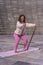 Vertical shot of a young caucasian woman doing squats using a resistant band