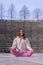 Vertical shot of a young caucasian woman sitting in an easy pose& x28;Sukhasana& x29;