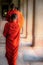 Vertical shot of young monks in orange dresses walking in a line