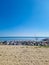 Vertical shpt of a heap of stones on sandy beach by the sea with blue sky n the horizon