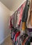 Vertical Small closet interior with colorful hanging clothes