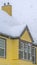 Vertical Snow falling on a yellow home in Daybreak Utah