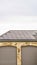 Vertical Solar panels installed on the garage roof of a home with cloudy sky background