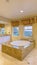 Vertical Spacious bathroom interior with built in bathtub two vanity areas and cabinets