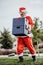 Vertical stock photo of papa noel without beard loading with two boxes of beer. Christmas time