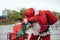 Vertical stock photo of santa claus supported in a bicycle full of gifts with exhausted expression. Christmas time