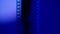 Vertical strip of blank film on blue gradient background close up. Processing negatives. Copy space.