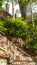 Vertical Sunlit stone stairway with black metal railing and brick house background