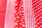 Vertical textural background of five types of red and white cotton fabric with different prints: checkered, striped, circle, star