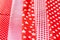 Vertical textural background of five types of red and white cotton fabric with different prints: checkered, striped, circle, star