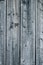 Vertical texture of grey weathered closely packed planks of a wooden fence