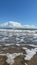 Vertical time-lapse shot of waves in the sea with clear blue sky in the background