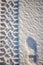 Vertical top view of a footprint and car wheel trail in the snow