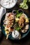 Vertical top view of plate of Souvlaki with sauce, vegetables, and flatbread