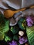 Vertical top view shot of numerous types of green vegetables with a wooden spoon beside them